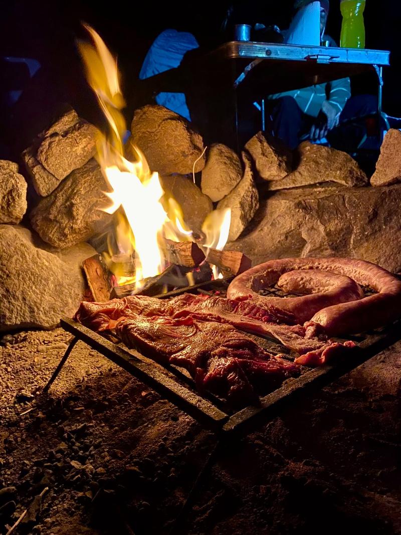 Asado grilling over an open fire at night, Mendoza